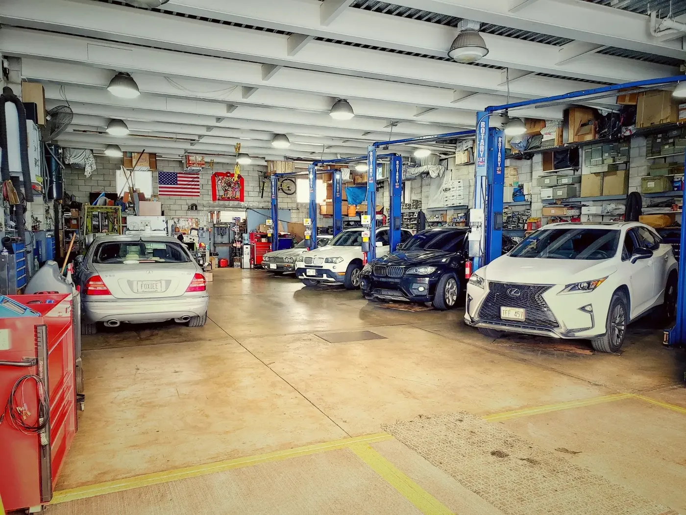 An auto repair shop floor with lifts and vehicles being serviced